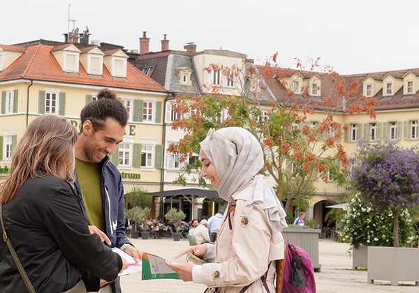 group of female and male individuals watching a map