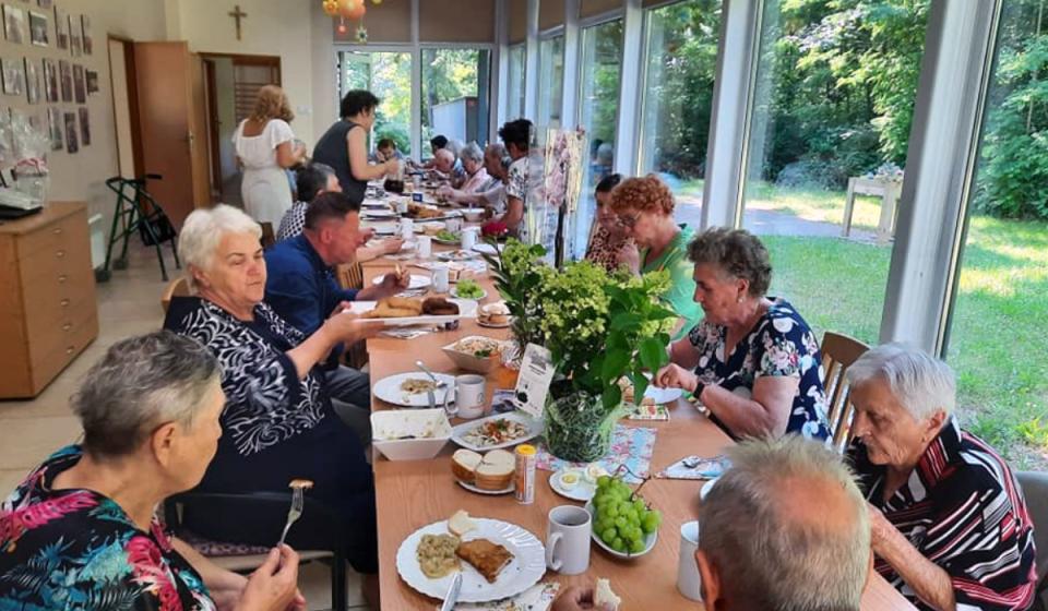 Elderly people sitting at the table and eating